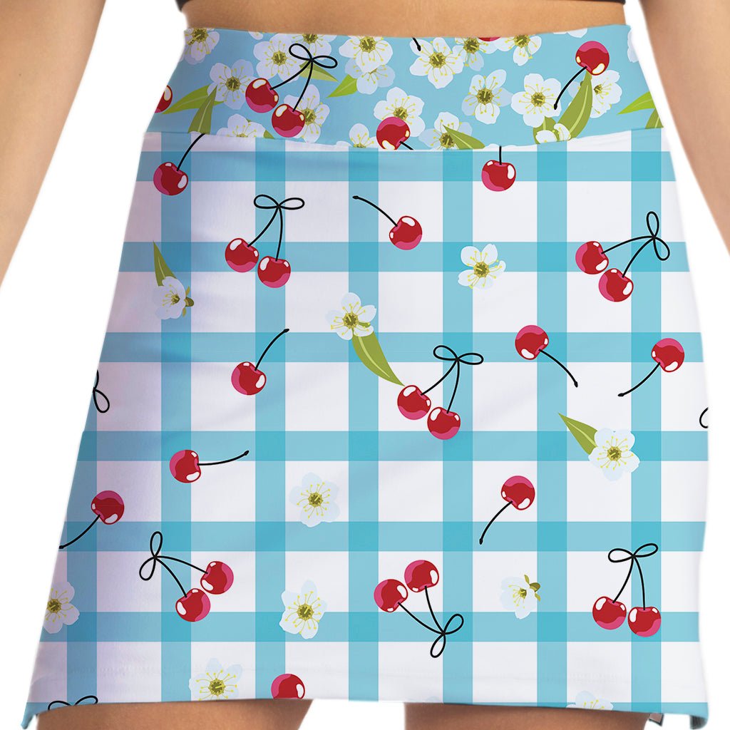 Skirt with blue checkered pattern, red cherries, and white flowers on a white background