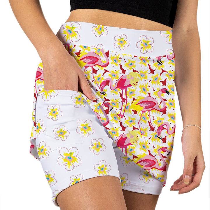 White shorts with pink flamingo and yellow flower pattern worn by a person.