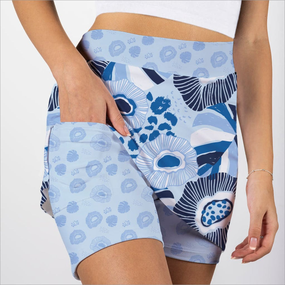 Blue and white patterned skorts worn by a person on a plain background