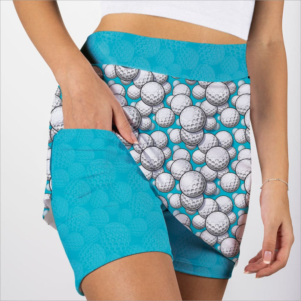 Person wearing a skort with golf ball pattern and turquoise accents