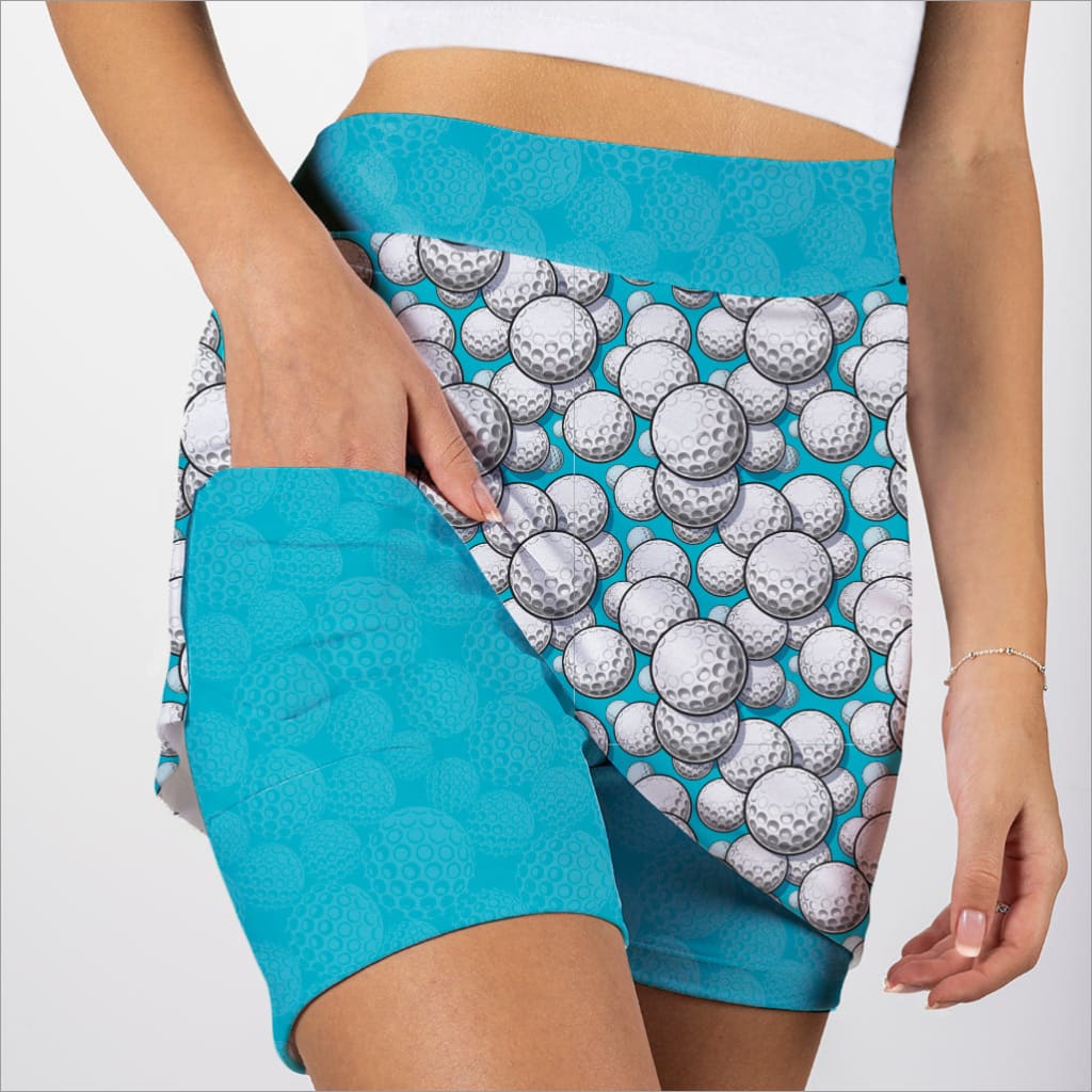 Person wearing a skort with golf ball pattern and turquoise accents