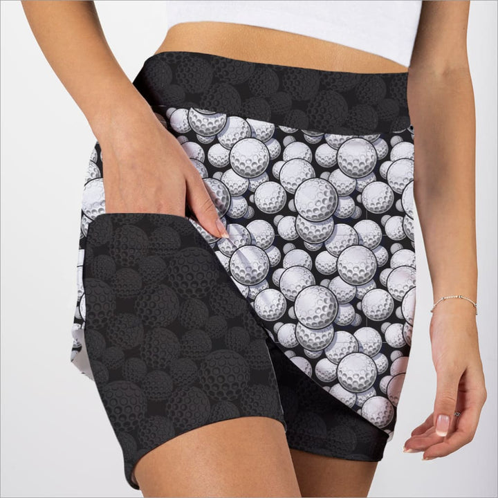 Person wearing skorts with golf ball pattern on a plain background