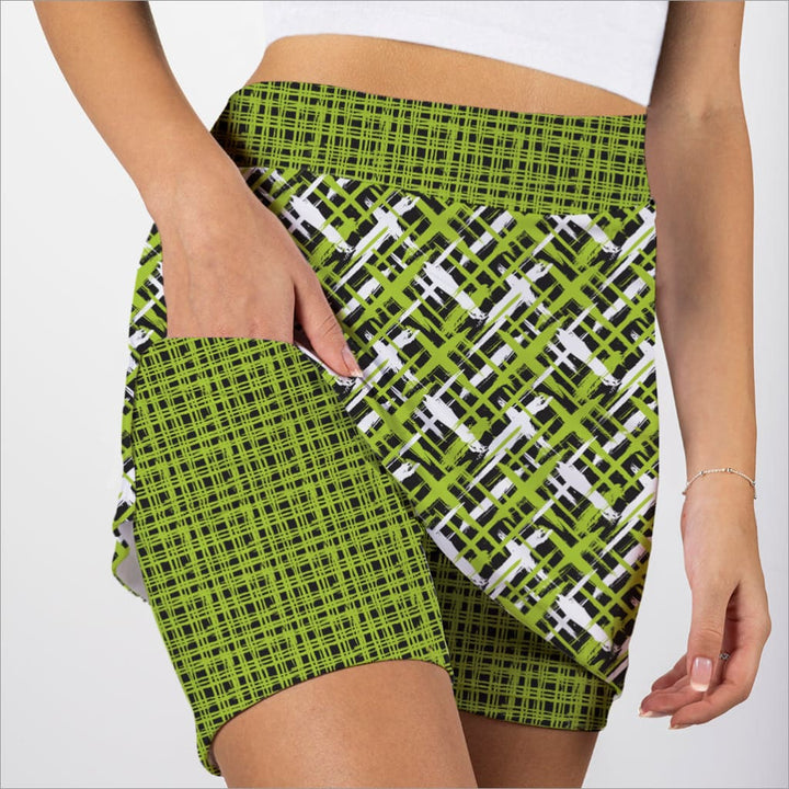 Green patterned skorts worn by a person on a white background
