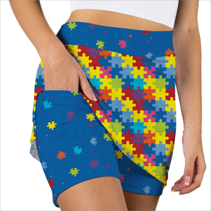 Colorful puzzle patterned shorts with a blue border worn by a person.